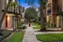 Charming brick apartment complex with lush green landscaping and inviting paths, perfect for tranquil evening strolls.