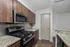 Modern kitchen with sleek stainless steel appliances, granite countertops, and elegant wood cabinetry.
