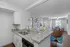 Elegant open-concept living space featuring a modern kitchen with granite countertops, cozy sitting area, and a sunlit dining room with stylish decor.