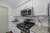 Modern kitchen with sleek granite countertops, stainless steel appliances, and elegant white cabinetry.