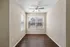 Bright and inviting room with hardwood flooring and large windows allowing ample natural light, perfect for a cozy office or reading nook.