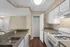 Charming kitchen with sleek countertops, white cabinetry, and a cozy pantry. Ample lighting enhances the warm atmosphere, perfect for culinary creativity.