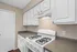 Sleek kitchen with white cabinetry and modern gas stove offering spacious countertops for culinary creativity.