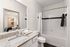 Elegant bathroom with sleek granite countertop, modern fixtures, and a spacious shower-tub combination, perfect for relaxation.