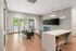 Contemporary living space with elegant design, featuring a sleek island countertop, modern lighting, and cozy seating area with large windows overlooking lush greenery.