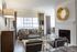 Sophisticated living room featuring modern furnishings, elegant fireplace, and abundant natural light streaming through large windows.