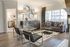 Elegant living room with chic modern decor, featuring a stylish gray sofa, geometric mirrors, and floor-to-ceiling windows for abundant natural light.