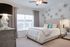 Elegant bedroom with soft lighting and modern decor, featuring a cozy upholstered bed and artistic wall details for a tranquil atmosphere.