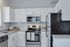 Modern kitchen with sleek white cabinets, stainless steel appliances, and elegant granite countertops.