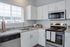 Modern kitchen with sleek white cabinets, granite countertops, and stainless steel appliances, offering a bright and inviting atmosphere.