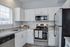 Modern kitchen with sleek stainless steel appliances, granite countertops, and stylish white cabinetry.
