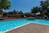 Inviting outdoor swimming pool area with sun loungers, surrounded by lush greenery and modern apartment buildings, perfect for relaxation and leisure.