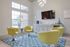 Contemporary living room with vibrant lime chairs, sleek modern furniture, and a wall-mounted TV, offering a perfect blend of comfort and style.