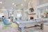 Luxurious entertainment room with a stylish pool table, cozy seating area, and modern d&eacute;cor, featuring a wall-mounted TV and elegant lighting.