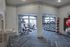Modern fitness center with state-of-the-art equipment, treadmills, weights, and exercise balls, featuring stylish flooring and natural light from large windows.