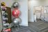 Modern apartment amenities featuring a vibrant play area for kids and a sleek, organized fitness corner with yoga balls and medicine balls.