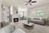 Elegant living room with a modern fireplace, plush gray furniture, and large windows inviting natural light.