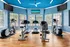 Inviting fitness center with modern cardio equipment, bright natural lighting, and stylish blue accents.
