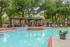 Inviting outdoor pool area with stylish pergola, comfortable seating, and lush greenery, perfect for relaxation and entertaining.