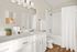 Bright and modern bathroom with chic white cabinetry, elegant fixtures, and natural wood flooring offering a relaxing ambiance.