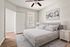 Bright and inviting bedroom with elegant decor, featuring a comfortable bed and minimalistic furnishings.