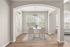 Bright and inviting dining area with elegant arches, a modern white table, and chic cream chairs, complemented by natural light and soft wood floors.