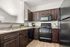 Modern kitchen with elegant dark wood cabinets, sleek black appliances, and a spacious countertop, perfect for culinary enthusiasts.