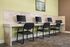 Modern communal workspace with marble countertops, equipped with three computers and comfortable seating.