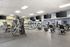 Spacious and modern gym with state-of-the-art exercise equipment, large mirrors, and flat-screen TVs, promoting a dynamic workout environment.