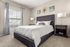 Elegant bedroom with a plush upholstered bed, cozy neutral tones, large window with natural light, and chic modern decor.