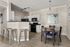 Contemporary kitchen-dining area with sleek countertops, modern appliances, and stylish bar stools. Inviting space enhanced by elegant lighting and a chic dining table.