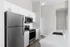 Modern kitchen with sleek stainless steel appliances, white cabinetry, and elegant quartz countertops.