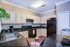 Charming kitchen with sleek black countertops, modern appliances, and ample cabinet space, perfect for culinary adventures.