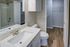 Modern bathroom with sleek fixtures, stylish vanity, and spacious walk-in closet featuring elegant wood flooring.