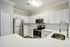 Modern kitchen with stainless steel appliances and elegant white cabinetry, featuring sleek countertops and a sophisticated subway tile backsplash.