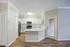 Modern kitchen with sleek white cabinetry, stainless steel appliances, and a spacious quartz countertop, beautifully illuminated by natural light.