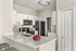 Modern kitchen with sleek white cabinets, elegant countertops, and contemporary appliances creating an inviting cooking space.