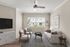 Bright and modern living room with elegant decor, cozy seating, and a large window offering a serene view.