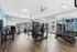 Bright and modern fitness center with state-of-the-art gym equipment and large mirrors, offering an invigorating workout experience.
