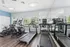 Modern gym with sleek treadmills, exercise bikes, and floor-to-ceiling mirrors, offering a bright and motivating workout space with natural light.