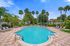 Luxurious outdoor pool area with crystal-clear water, surrounded by palm trees and comfortable lounge chairs, perfect for relaxation and leisure.