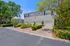 Charming residential complex with elegant grey facades, manicured greenery, and convenient garages highlighting modern suburban living.