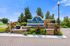 Inviting entrance of Citrus Tower Apartment Homes featuring a beautifully landscaped area with vibrant plants and modern stonework under a clear blue sky.