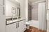 Elegant modern bathroom with sleek vanity, contemporary fixtures, and a luxurious bathtub with stylish tile surround.