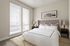 Inviting bedroom with elegant tufted headboard, soft natural light, and chic modern decor.