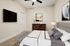 Modern bedroom featuring a plush grey upholstered bed, elegant wooden dresser, and contemporary art for a serene living space.