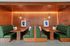 Chic dining alcove with elegant wooden paneling, plush green booths, and geometric lighting adding a modern touch.