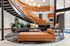 Modern lobby with a chic circular sofa, unique wooden spiral staircase, and elegant lighting, creating a welcoming ambiance.