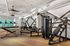 Modern gym with state-of-the-art fitness equipment, sleek design, and vibrant wall art, ideal for an energetic workout experience.