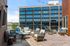 Chic urban rooftop patio with cozy seating and vibrant cushions, perfect for outdoor relaxation and entertaining.